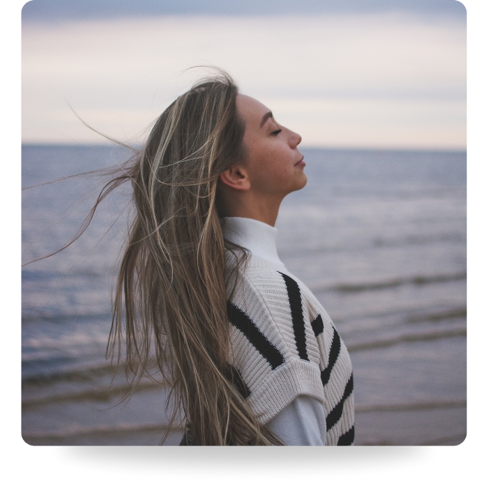 woman doing breathing exercise in nature on beach
