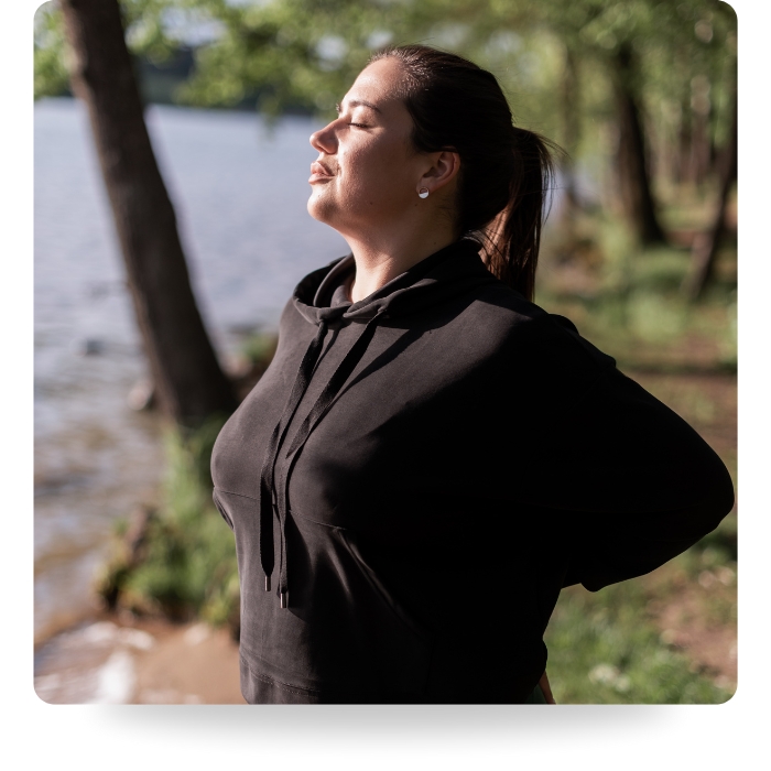 woman doing breathing exercises on nature walk